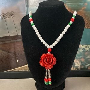 Glass beaded strand of necklace with rose polymer pendant.